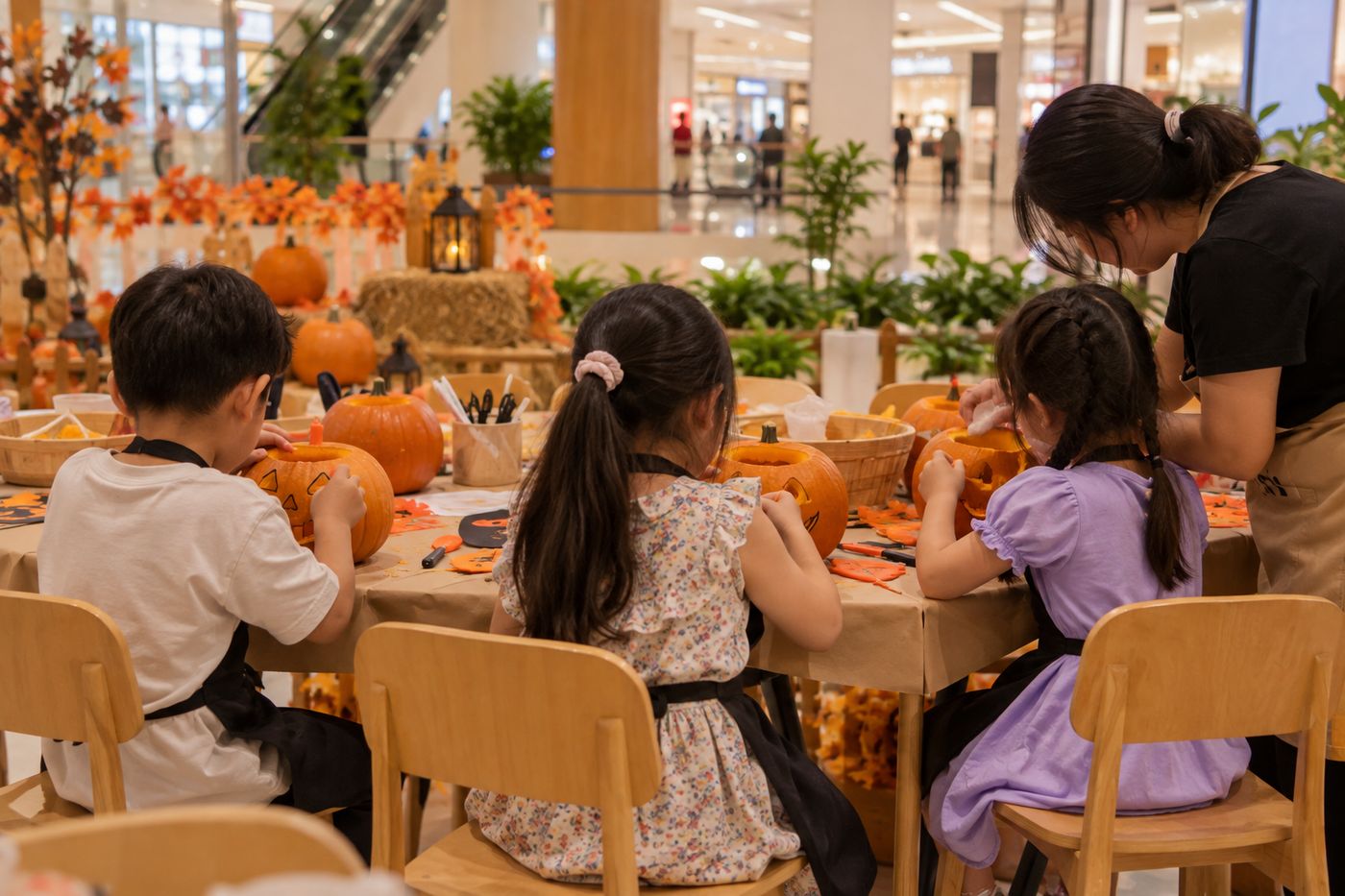 Các bé khắc bí ngô tại buổi workshop Halloween trong trung tâm thương mại